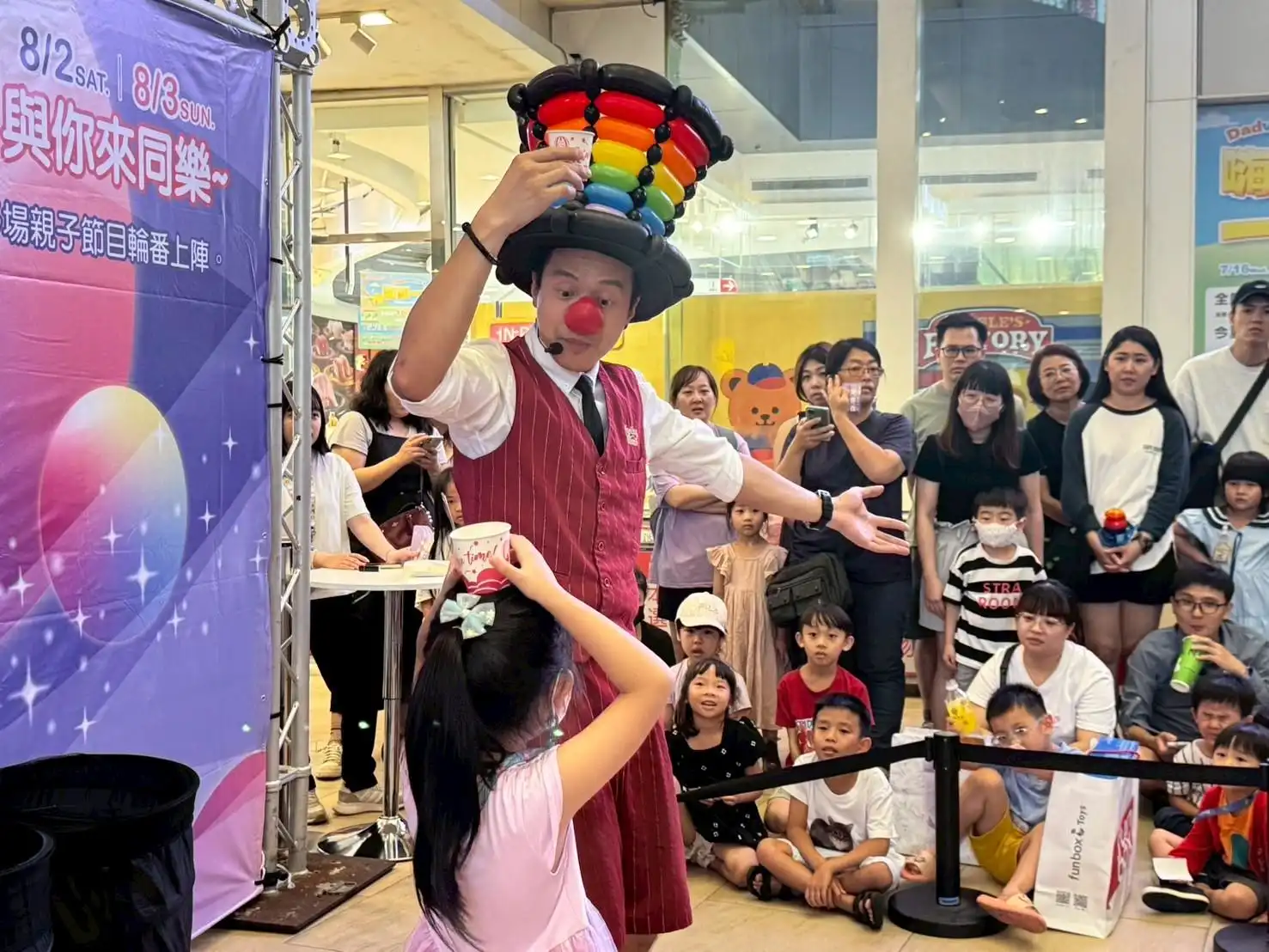 氣球大叔在孩子頭上表演消失的水魔術，現場笑聲不斷