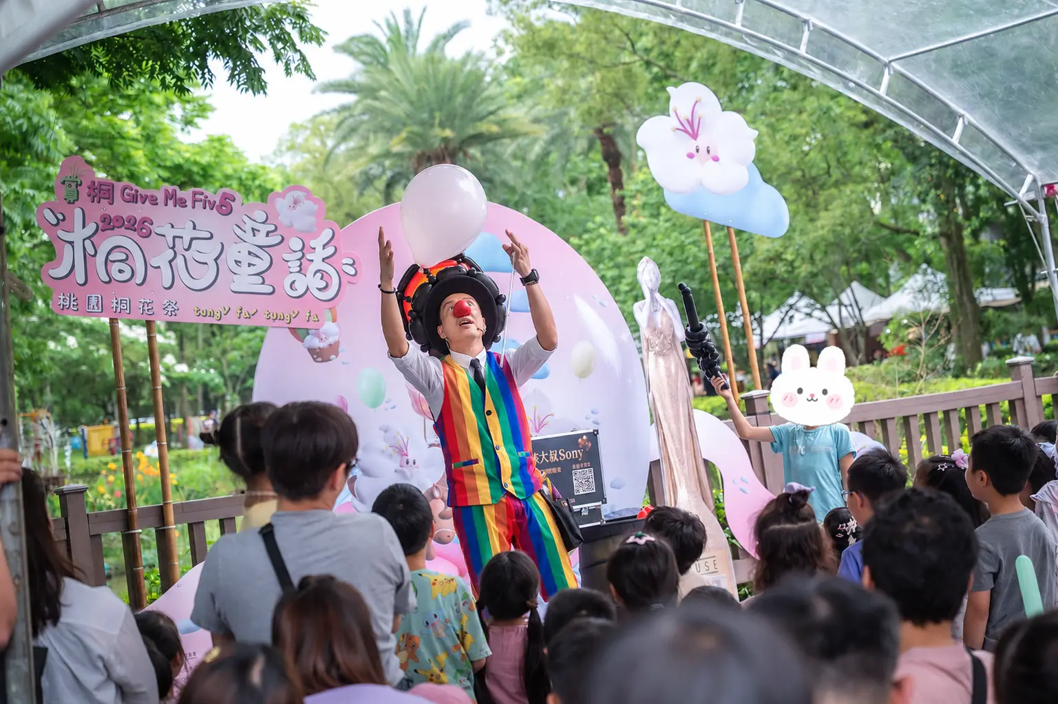 氣球大叔 Sony 於桃園客家文化館拋接白色大氣球，現場大批親子觀眾專注觀看舞台表演