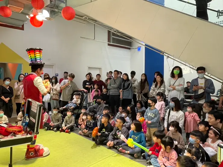 氣球、魔術表演者在台中 IKEA 周年慶現場進行親子互動演出,現場觀眾圍繞觀看,包含眾多小朋友與家長