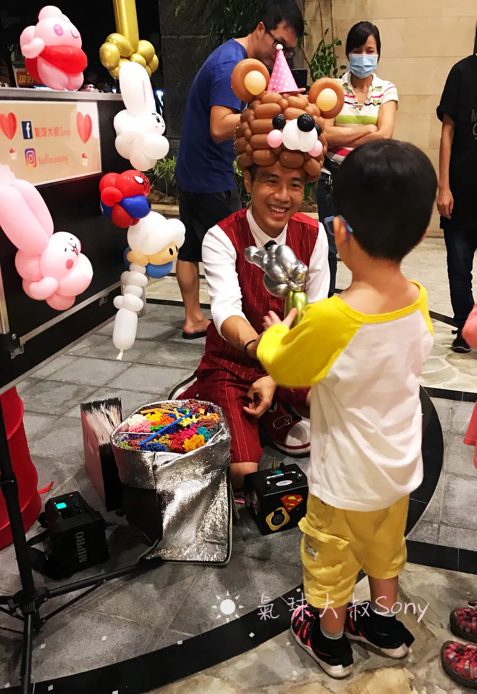 基隆社區中秋活動現場，氣球手折與魔術互動，構成溫馨場面