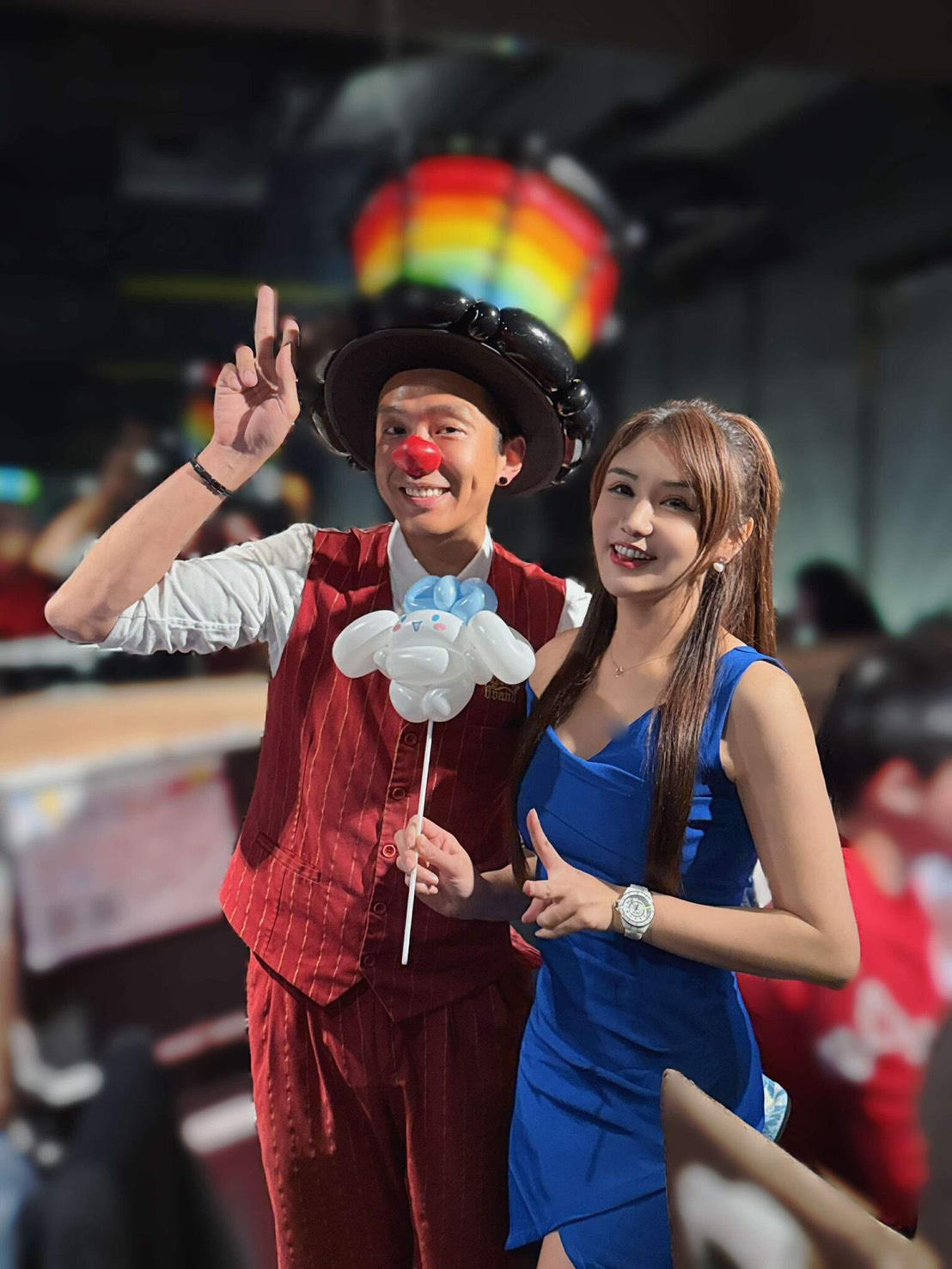 氣球大叔 Sony 與尾牙主持人倪倪合照，倪倪手拿精緻大耳狗氣球作品