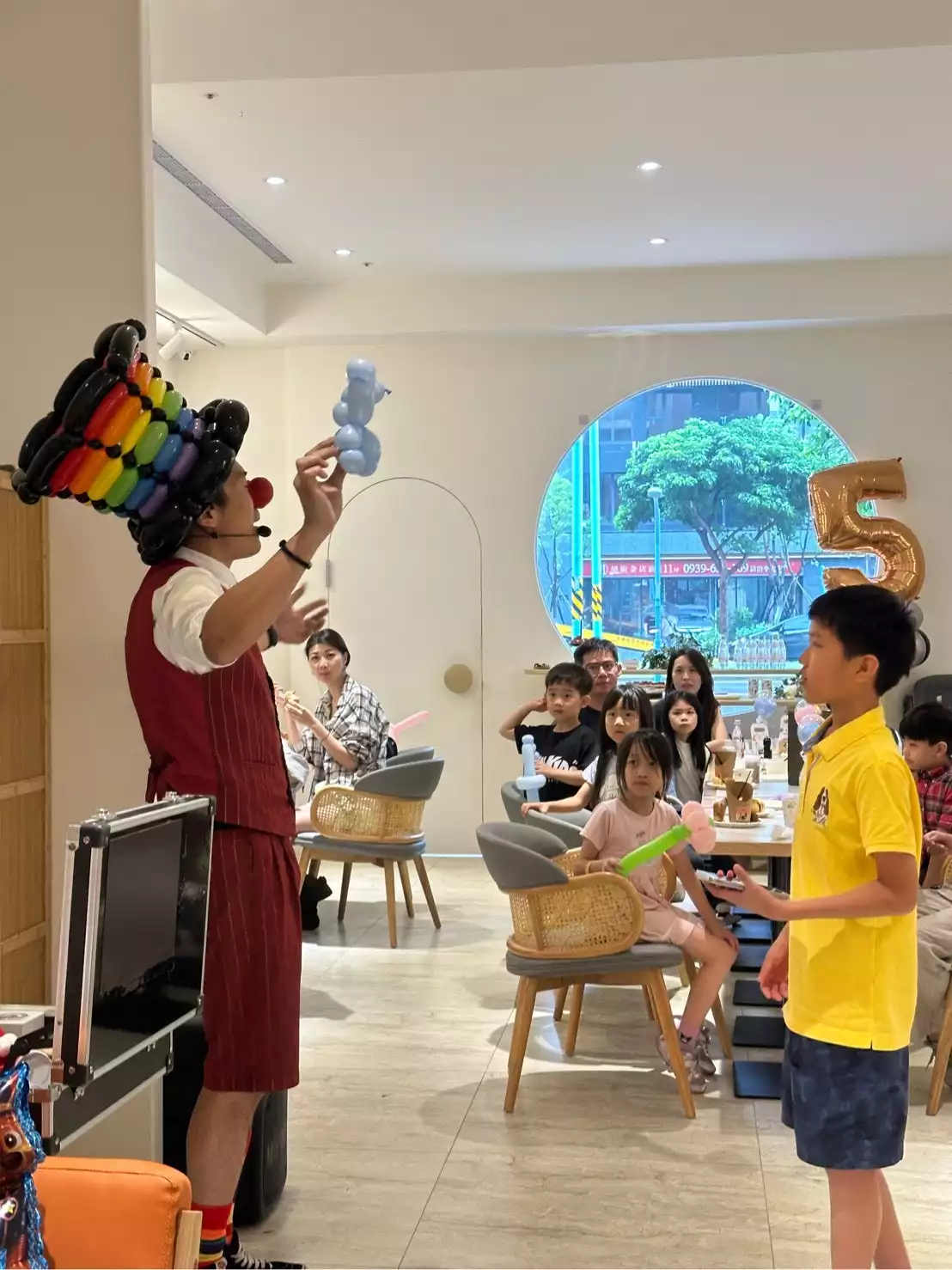 氣球大叔展示藍色氣球小熊，台下孩子們聚精會神