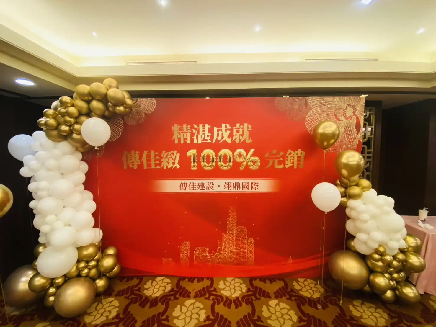 桃園尊爵大飯店傳佳建設100%完銷慶功宴，紅色主視覺背板搭配金白氣球拱門佈置