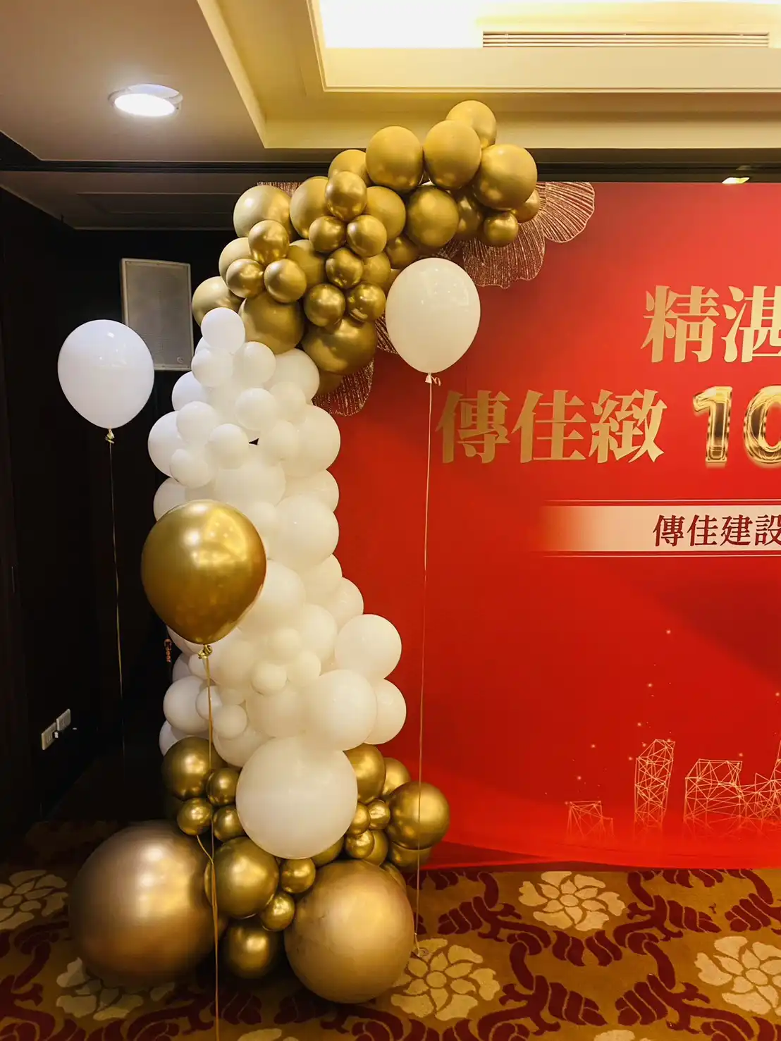 桃園尊爵大飯店活動會場，金白氣球搭配傳佳緻建案100%完銷慶功背板，氛圍隆重