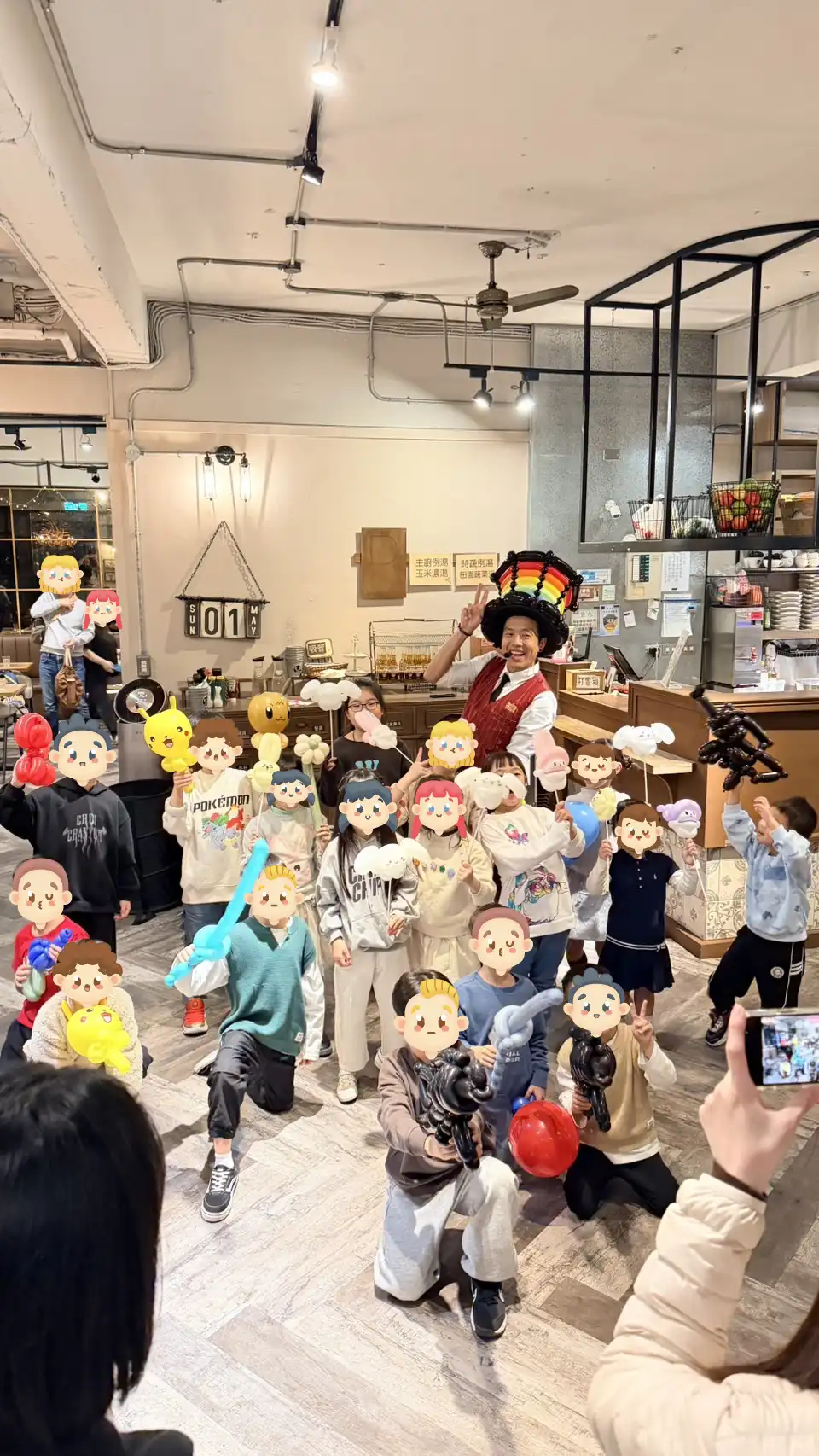 氣球大叔與一群手拿造型氣球的小保護在鹿角公園餐廳內開心大合照