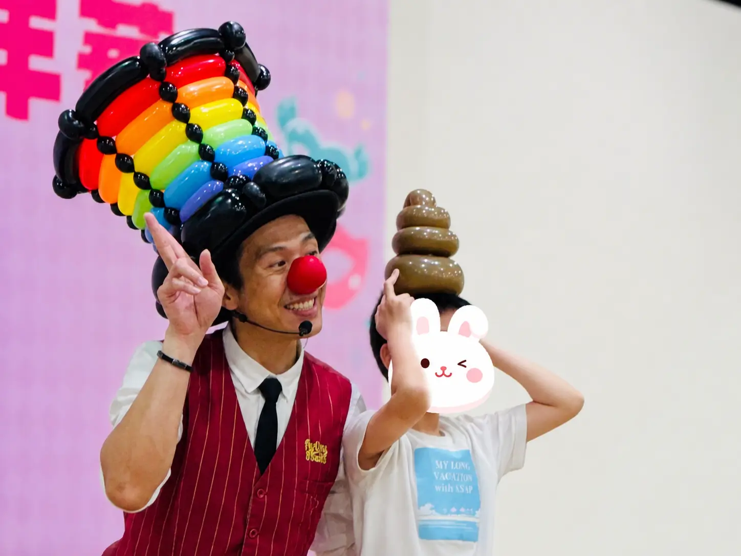氣球大叔 Sony 現場折出經典咖啡色便便造型氣球戴在小男孩頭上，互動充滿童趣與幽默